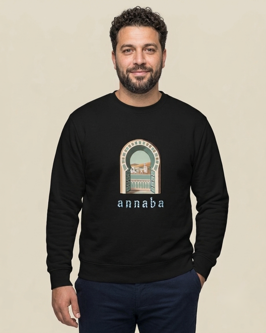 Homme nord-africain portant le sweatshirt Annaba Bella Vista noir qalbi, arche méditerranéenne et mention annaba sur la poitrine