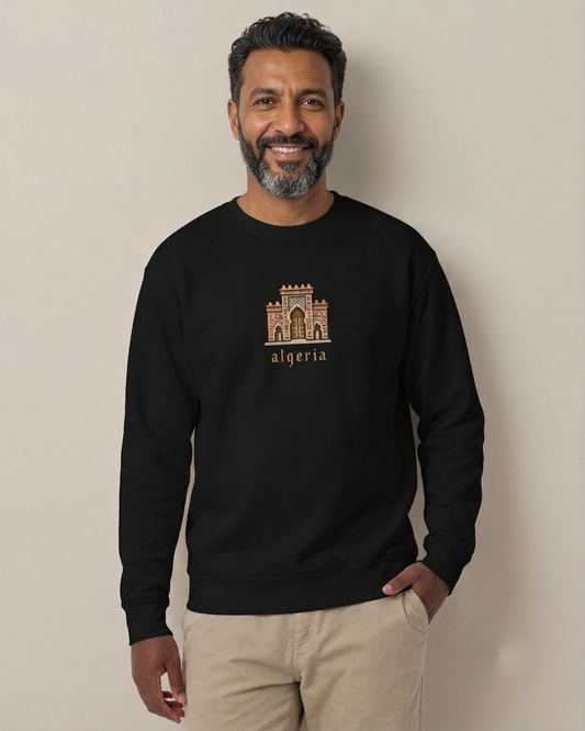 Homme nord-africain portant le sweatshirt Porte algérienne 8 bits noir qalbi, logo pixel art de la porte traditionnelle sur la poitrine