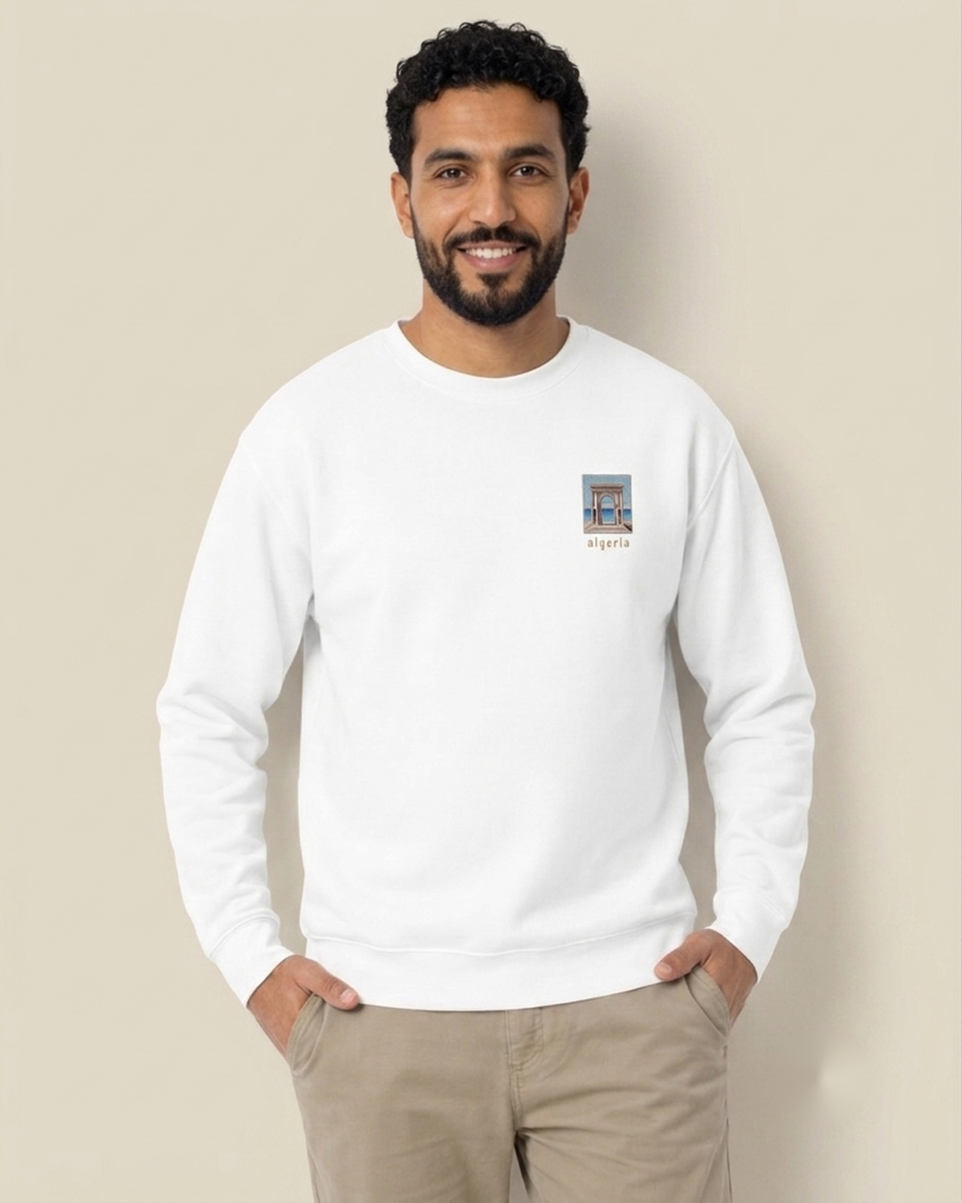 Homme nord-africain portant le sweatshirt Seafront 8 bits blanc qalbi, logo pixel art du front de mer algérien sur la poitrine