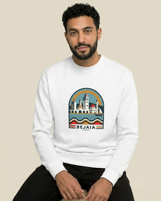 Homme nord-africain portant le sweatshirt Béjaïa The Pearl blanc qalbi, illustration du front de mer kabyle et du phare de Béjaïa